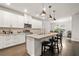 Modern kitchen with white cabinets, granite countertops, and a central island with seating at 3695 Townley Ln, Cumming, GA 30040