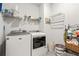 Functional laundry room with modern washer and dryer and storage shelving at 3695 Townley Ln, Cumming, GA 30040
