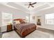 Spacious main bedroom featuring trey ceiling, two windows, and a walk-in closet with wood floor at 3695 Townley Ln, Cumming, GA 30040
