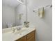 Half bathroom features a wooden vanity, mirror, and towel rack at 5450 Taylor Rd, Johns Creek, GA 30022