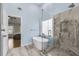 Modern bathroom featuring a soaking tub, glass-enclosed shower, and marble accents adjacent to the main bedroom at 5450 Taylor Rd, Johns Creek, GA 30022