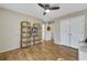Bedroom with ceiling fan, wood floors, bookshelf, and ample closet space for storage at 5450 Taylor Rd, Johns Creek, GA 30022