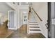 Inviting foyer with a staircase and tile flooring leading into a hallway with hardwood floors at 5450 Taylor Rd, Johns Creek, GA 30022