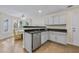 Bright kitchen with white cabinets, stainless steel dishwasher and black granite counters overlooking breakfast area at 5450 Taylor Rd, Johns Creek, GA 30022