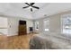 Spacious main bedroom featuring tray ceilings, a ceiling fan, windows, and wood-look flooring at 5450 Taylor Rd, Johns Creek, GA 30022