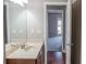 Well-lit bathroom with a large mirror, single sink vanity, and hardwood floors that extend into the bedroom at 2733 Madison Mae Ln, Grayson, GA 30017