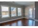 Living room with hardwood floors, three large windows, and French doors at 2733 Madison Mae Ln, Grayson, GA 30017