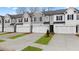 Attractive townhomes feature modern exteriors, white garage doors, and well-manicured lawns with tree and green grass accents at 305 Sound Cir, Stockbridge, GA 30281