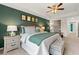 Comfortable main bedroom featuring a green accent wall, ceiling fan, and stylish decor at 305 Sound Cir, Stockbridge, GA 30281