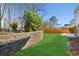 Landscaped backyard with a retaining wall and grassy area at 4345 Settlers Grove Rd, Cumming, GA 30028