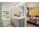 Double vanity bathroom with gray cabinets and en-suite access to bedroom at 301 Sound Cir, Stockbridge, GA 30281