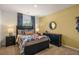 Youthful bedroom featuring a black bed, dark dresser, and pops of color in a room with carpeted floors at 301 Sound Cir, Stockbridge, GA 30281