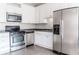 Kitchen boasts white cabinets, stainless steel appliances, and tile flooring at 335 Wilma Sw Ct, Atlanta, GA 30331