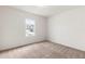 A well-lit bedroom featuring neutral carpet and a window offering neighborhood views at 3745 Newbury Place Dr, Loganville, GA 30052