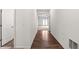 A well-lit hallway featuring hard wood floors and white walls at 3745 Newbury Place Dr, Loganville, GA 30052