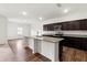 Modern kitchen featuring stainless steel appliances, granite countertops and dark wood cabinets at 3745 Newbury Place Dr, Loganville, GA 30052