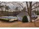 A fenced-in pool and tennis court area surrounded by mature trees in a residential community at 4405 Maple Valley Dr, Cumming, GA 30040