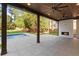 Covered backyard patio featuring a fireplace, ceiling fans, and a view of the pool and lush landscaping at 3661 Clubwood Trl, Marietta, GA 30068