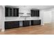 Finished basement featuring a wet bar with dark cabinets, quartz countertops, and hardwood floors at 3661 Clubwood Trl, Marietta, GA 30068