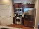 Kitchen showcasing stainless steel appliances, dark cabinetry, and wood flooring at 4805 West Village Way # 3207, Smyrna, GA 30080