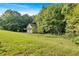 Landscaped yard with lush greenery bordering a wooded area at 49 Ne Kay Rd, White, GA 30184