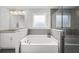 Luxurious bathroom featuring a soaking tub, granite countertops, and a glass-enclosed shower at 679 Mcwilliams Se Rd, Atlanta, GA 30315
