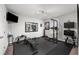 Home gym with weights, bench, pull up rack, rubber floor, and wall-mounted TV at 679 Mcwilliams Se Rd, Atlanta, GA 30315
