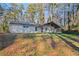 Quaint home with a covered porch surrounded by a natural landscape with mature trees at 550 S Rays Rd, Stone Mountain, GA 30083