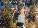 Aerial view showcasing a large green building and an adjacent road, with a lake visible in the background at 2697 Bethel Ne Rd, Conyers, GA 30012