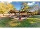 Outdoor pavilion with numerous picnic tables and red trash cans, set against a backdrop of trees and a lake at 2697 Bethel Ne Rd, Conyers, GA 30012