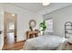 Bright bedroom with hardwood flooring, white walls, and a decorative mirror at 332 Shadowmoor Dr, Decatur, GA 30030