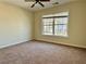 This bedroom features neutral walls and carpet, with a window view of the neighborhood at 7972 Applemist Dr, Fairburn, GA 30213