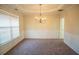 Formal dining room featuring a tray ceiling, elegant chandelier, and wainscoting at 7972 Applemist Dr, Fairburn, GA 30213