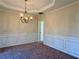 Elegant dining room with chair rail, crown molding, and a chandelier at 7972 Applemist Dr, Fairburn, GA 30213