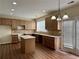 Kitchen featuring wood cabinets, island with countertop, backsplash, and modern lighting at 7972 Applemist Dr, Fairburn, GA 30213