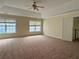 This main bedroom has tray ceilings, neutral walls and carpet, and large windows at 7972 Applemist Dr, Fairburn, GA 30213