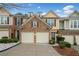 Two-story townhome with stone and siding exterior, three-car garage, and landscaping at 1693 Fair Oak Way, Mableton, GA 30126