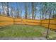Backyard featuring a full wooden fence, grassy area, and mature trees in the background at 1693 Fair Oak Way, Mableton, GA 30126