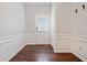 Bright foyer featuring beautiful wood-look floors, wainscoting, and a view of the front door at 1693 Fair Oak Way, Mableton, GA 30126