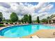 Community pool featuring lounge chairs, mature trees, and a blue sky at 1693 Fair Oak Way, Mableton, GA 30126