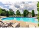 Community pool featuring lounge chairs, mature trees, and a blue sky at 1693 Fair Oak Way, Mableton, GA 30126