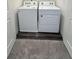 Convenient laundry room with washer and dryer and dark grey luxury vinyl plank flooring at 178 Rydal Way, Winder, GA 30268