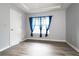 Bedroom with wood-look floors, window with blue curtains, and a door at 225 Bentley Pl, Tucker, GA 30084