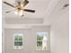 Bedroom showcasing a ceiling fan, a tray ceiling and bright natural light from its double windows at 297 Sound Cir, Stockbridge, GA 30281