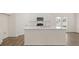 View of a kitchen island with white cabinets and a quartz countertop at 297 Sound Cir, Stockbridge, GA 30281