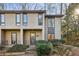 Tan two-story townhome with dark brown window frames and a lush green landscape at 54 Ivy Ne Pkwy, Atlanta, GA 30342