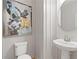 Powder room features a pedestal sink, round mirror, and abstract art at 2416 Cadenza Cir, Dacula, GA 30019