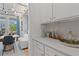 Built-in wet bar with white cabinets and quartz countertop at 2416 Cadenza Cir, Dacula, GA 30019