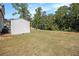 A view of the storage shed and large yard, surrounded by mature trees in the backyard at 220 Seth Ter, Mcdonough, GA 30252