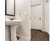 Main floor bathroom with pedestal sink and dark wood floors at 220 Seth Ter, Mcdonough, GA 30252